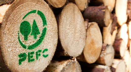 Blick auf einen Holzpolter mit grünem PEFC-Logo
