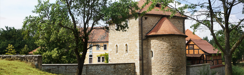 Blick auf ein Historisches Gebäudeensemle, das an eine mittelalterliche Burganlage erinnert