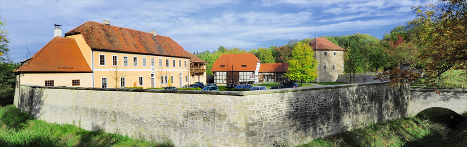 Blick auf das historsche Forsthaus Willrode: Historisches Fachwerk-Gebäudein warmen Farbtönen an einem Sommertag