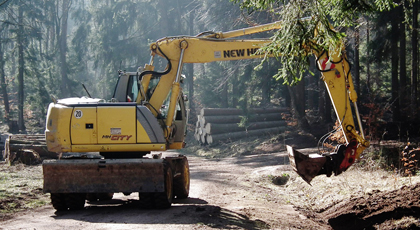Bagger im Wald hebt die Seitengräben der Waldwege aus
