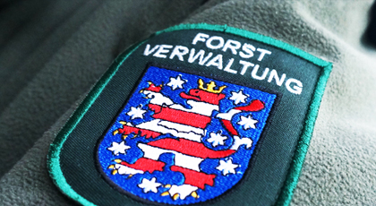 Blick auf ein Forstwappen an einer dunkelgrünen Fleecjacke