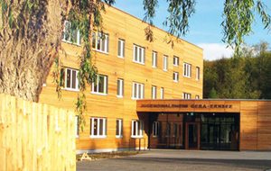 Jugendwaldheim Gera-Ernsee: Moderner Flachbau mit Holzfassade vor grüner Waldlandschaft